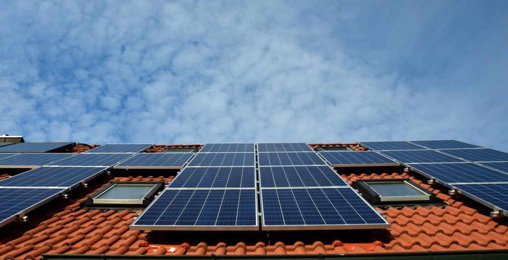 Un edificio de viviendas con un sistema de paneles solares de autoconsumo en el tejado.