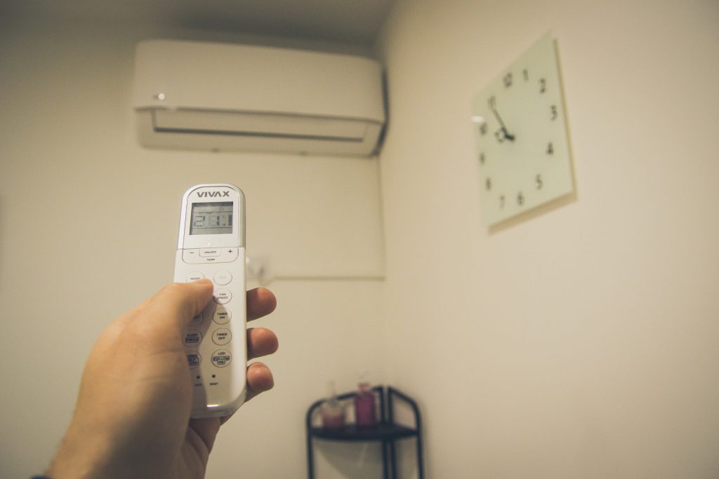 Una persona ajusta la temperatura de su aire acondicionado.